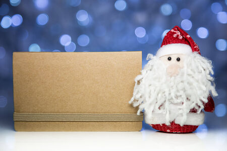 Santa Claus or Father Frost and greeting blank card from craft paper with Christmas lights on backgroundの写真素材