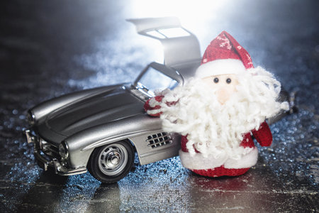 Santa Claus or Father Frost with old vintage automobile on on silver or metal grunge surface with...