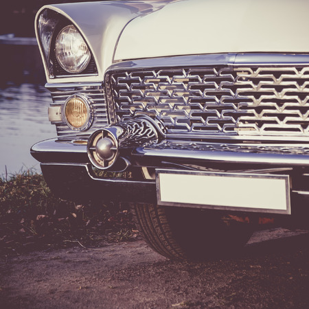 Old retro or vintage car or automobile front side with front lights or headlights and radiator grill. Processed by vintage or retro effect filterの写真素材