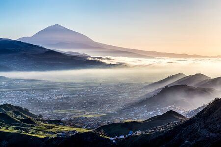 Sunset at evening in mountains and blue sky with fog or haze and Teide volcano on background in Tenerife Canary island, Spainの写真素材