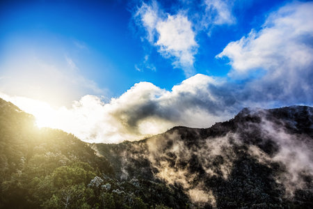 Green mountains or rocks with clouds and sun with sunlight on sky landscape in Tenerife Canary...