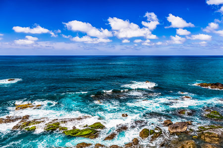 Stone shore of Atlantic ocean and sky with clouds and skyline or horizon landscape in Tenerife Canary island, Spain at spring or summerの写真素材