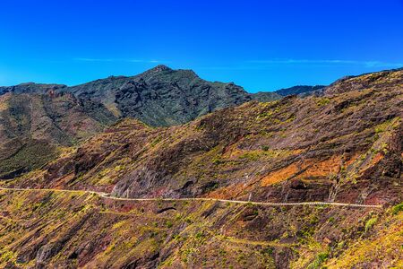 Winding or serpantine road in mountain or rock with blue sky in Tenerife Canary island, Spain at spring or summerの写真素材