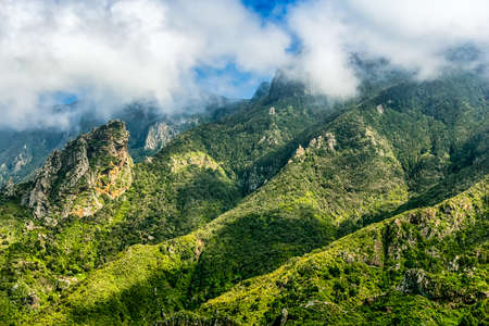 Green mountain and rocks with cloudsの写真素材