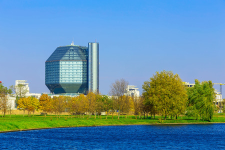 Landscape with Office Building Among Trees on Green Grass near Blue Lakeの写真素材
