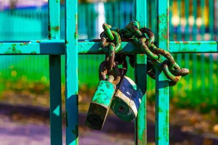 Main Focus of Image on Metal Fence with Rusty Lock and Chain on Blurred Backgroundの写真素材