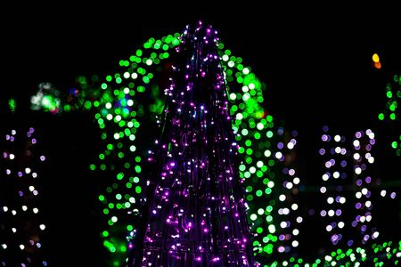 Christmas Tree made from Christmas Lighting Garland on Colorful Lights in Backgroundの写真素材