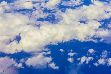 View on blue sky over white clouds or cloudscape from airplaneの写真素材