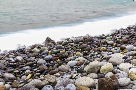 Stone Beach of Atlantic Ocean with Waves and Foam from long exposure on Tenerife or Canary Islandの写真素材