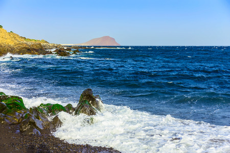 Stone Coast of Ocean with Waves and Sky on Tenerife Canary Island in Spain at Dayの写真素材