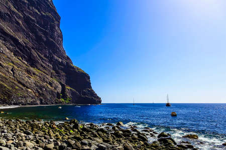 Stone Coast or Shore of Atlantic Ocean with Waves and Sky on Tenerife Island in Spain at Dayの写真素材