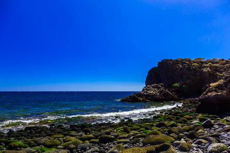 Stone Coast or Shore of Atlantic Ocean with Waves and Sky on Canary Island in Spain at Dayの写真素材