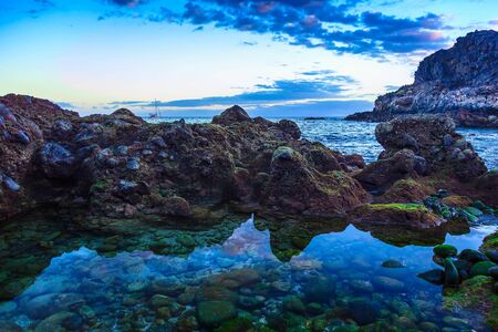 Stone Coast or Shore of Atlantic Ocean with Sky Reflection in water on Canary Islandの写真素材
