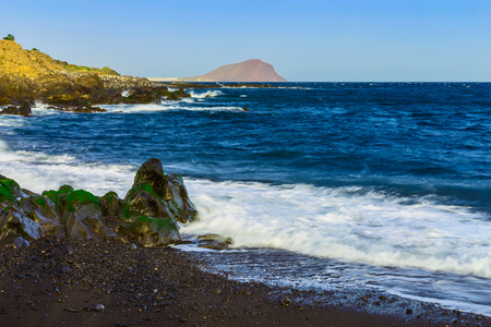 Stone Coast of Ocean with Waves on Tenerife Canary Island at Dayの写真素材