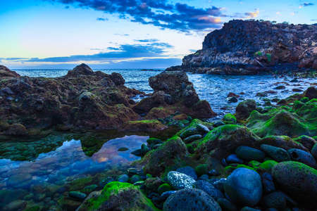 Stone Coast or Shore of Atlantic Ocean with Sky Reflection in water on Tenerife Islandの写真素材