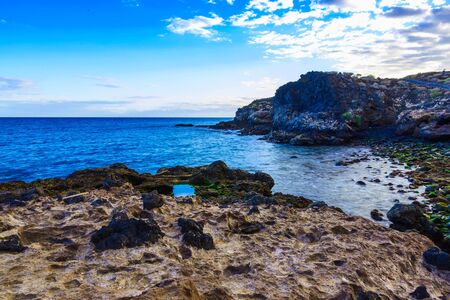 Stone Beach of Ocean with Waves and Sky on Tenerife Island in Spain at Dayの写真素材