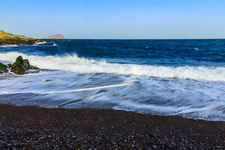 Stone Shore of Ocean with Waves and Sky on Tenerife Island in Spain at Dayの写真素材