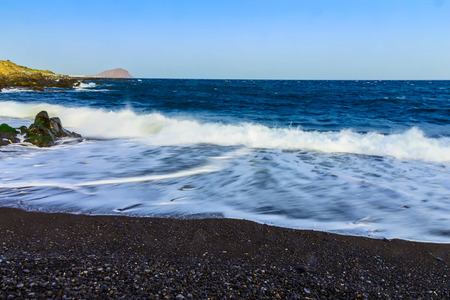 Stone Shore of Atlantic Ocean with Waves on Tenerife Canary Island at Dayの写真素材