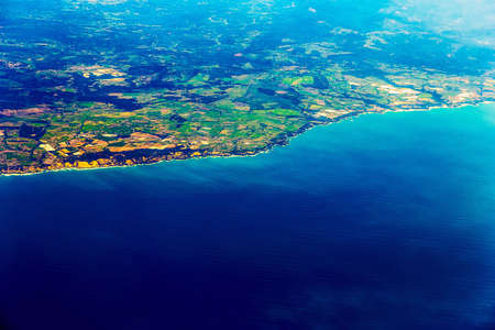 Island Coast with City in Ocean Aerial view from Planeの写真素材