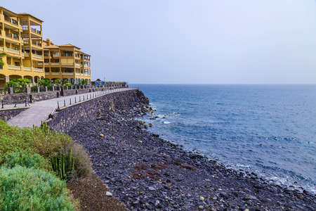 Rock Coast or Shore of Atlantic Ocean with Buildings Seascape on Canary Island at Dayの写真素材