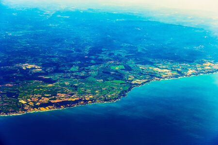 Island Coast with City in Ocean Aerial view from Planeの写真素材
