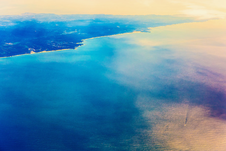 Island Coast with City in Ocean Aerial view from Planeの写真素材