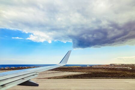 Wing of Plane at Tenerife Canary Island Coast Backgrond. View from Plane Runwayの写真素材