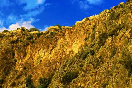 Castle wall on hill on background of blue sky at sundown in Alanya, Turkeyの写真素材