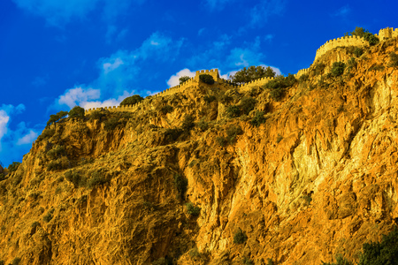 Castle wall on mountain on background of blue sky in Alanya, Turkeyの写真素材