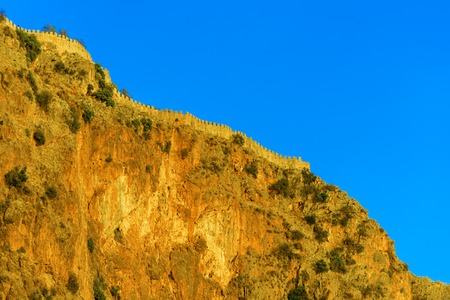 Castle wall on hill on background of blue sky in Alanya, Turkeyの写真素材