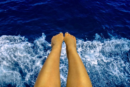 Woman holding her feet above sea during boat trip in Alanya, Turkeyの写真素材