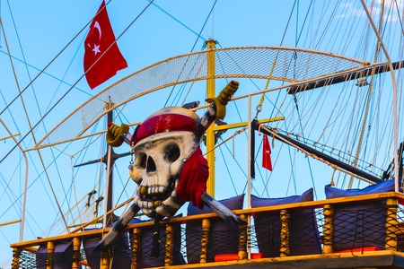 Tourist ship with Turkish flag and decorated as pirate skull and crossbones in Alanya, Turkeyの写真素材