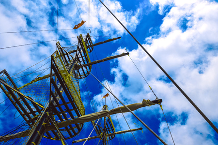 View from bottom on wooden ship's mast against blue sky with clouds in Alanya, Turkeyの写真素材