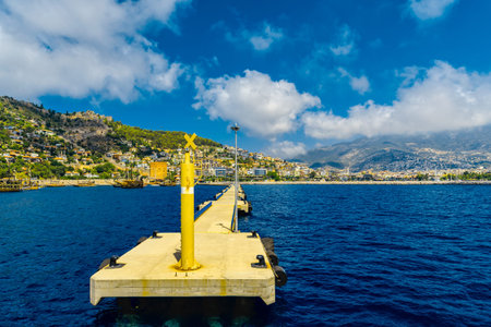 Long pier at the entrance to the seaport and mountain views in Alanya at sunset, Turkeyの写真素材