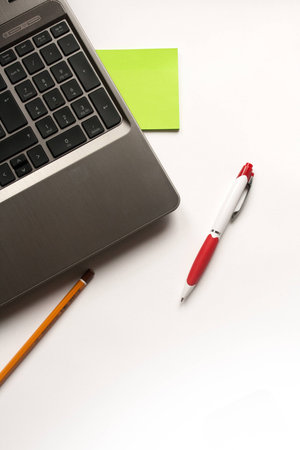 Laptop, pencil and pen on white background