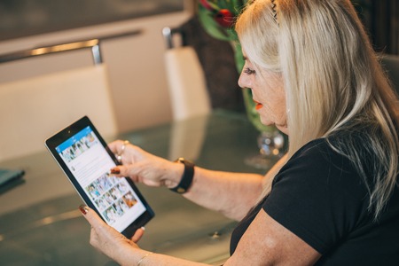 woman 65-70 years old using   tablet pc computer at homeの写真素材