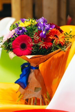 Flowers bouquet of gerbera, iris, pistacia on coloroful backgroundの写真素材