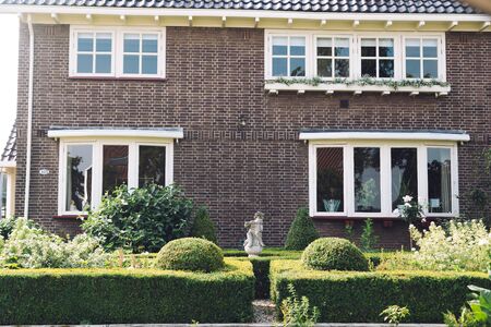 bushes in front of the house on a sunny dayの写真素材