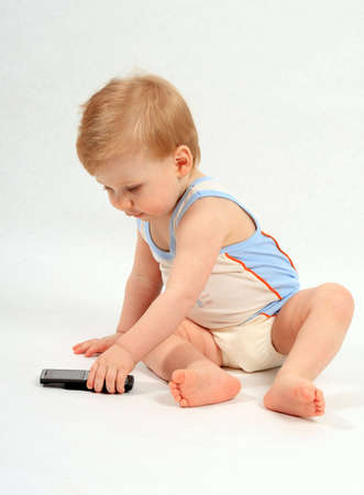 The small beautiful boy with curiosity examines a mobile phoneの写真素材