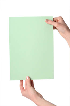 Hands hold a green leaf for advertising on a white backgroundの写真素材