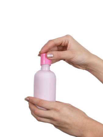 The female hands holds on an open palm a small bottle with perfumery on a white backgroundの写真素材