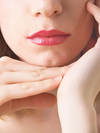 Lips and the bottom part of the person of the beautiful woman in bright lipstick of red colorの写真素材