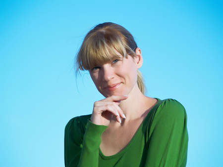 Portrait of the young woman posing on a background of the dark blue skyの写真素材