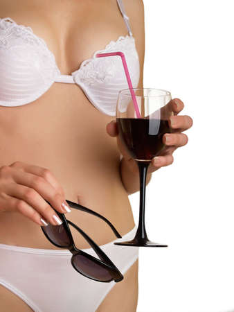 The young woman in underwear on a white background with glasses and wine in a handの写真素材