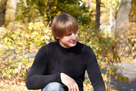 Attractive young man siting in the parkの写真素材