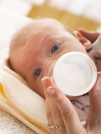 The child drinks milk from a bottleの写真素材