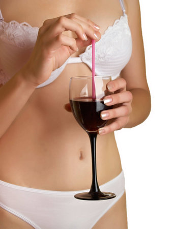 The young woman in underwear on a white background with  wine in a handの写真素材