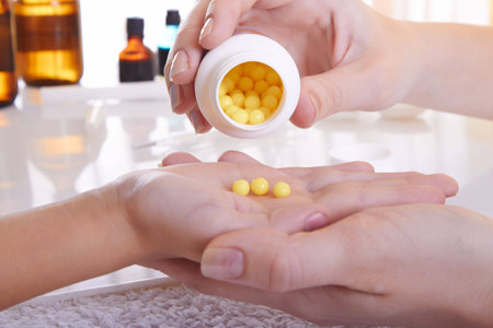 The doctor pours out vitamins on a palmの写真素材