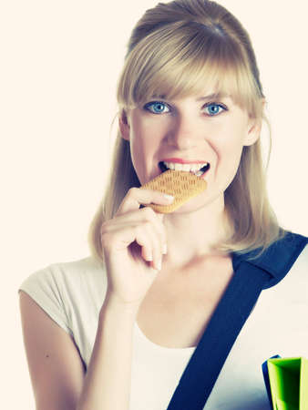 The young student eats cookies on isolatedの写真素材