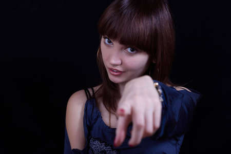 Portrait of the young woman a hand doing gesture on a black backgroundの写真素材